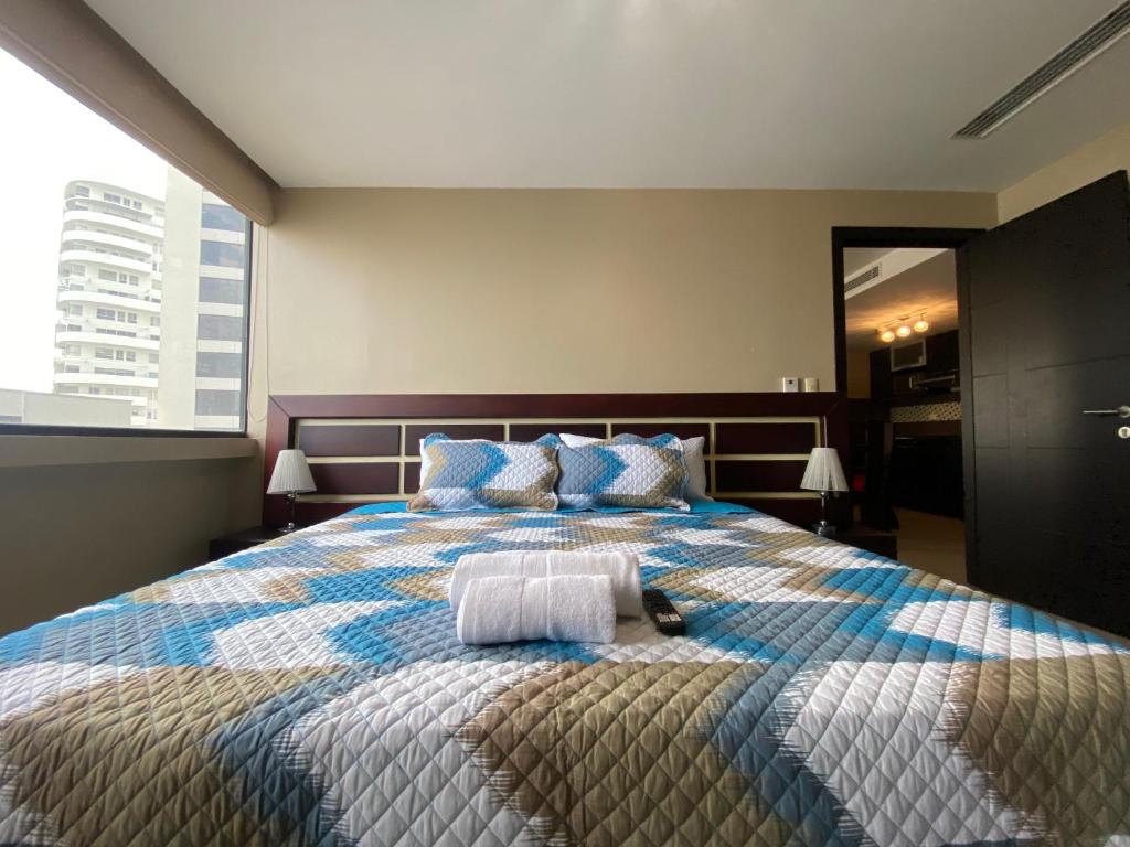 1 dormitorio con 1 cama grande con almohadas azules en Suite de lujo en la ciudad Puerto Santa Ana, en Guayaquil