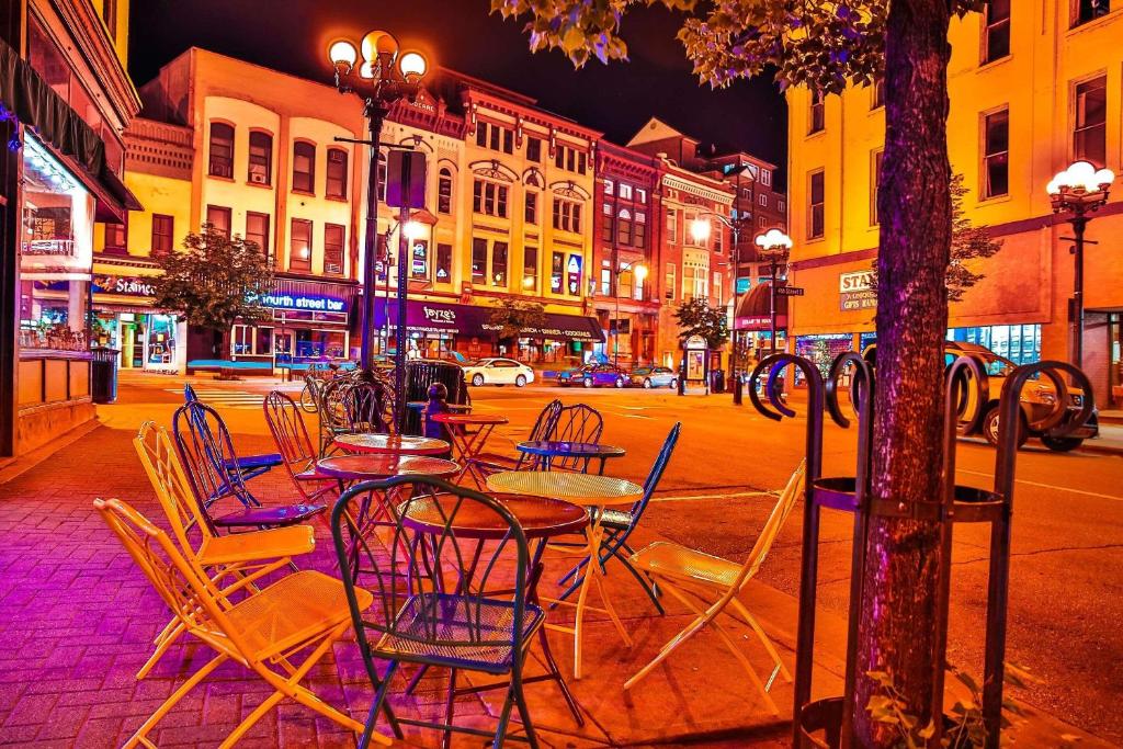 a group of tables and chairs on a city street at night at Radisson Hotel La Crosse in La Crosse