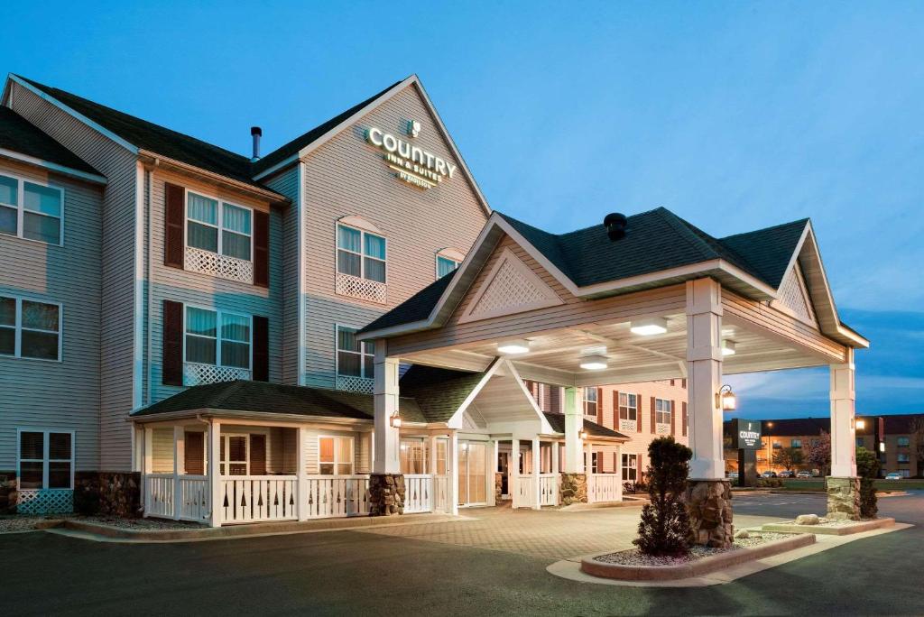un hotel con un cartel en la parte delantera en Country Inn & Suites by Radisson, Stevens Point, WI, en Stevens Point