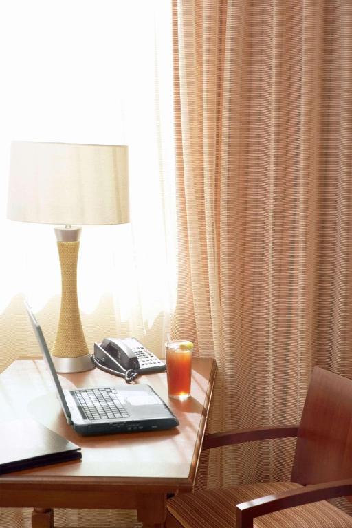 a laptop on a table with a lamp and a candle at Country Inn & Suites by Radisson, Beckley, WV in Beckley