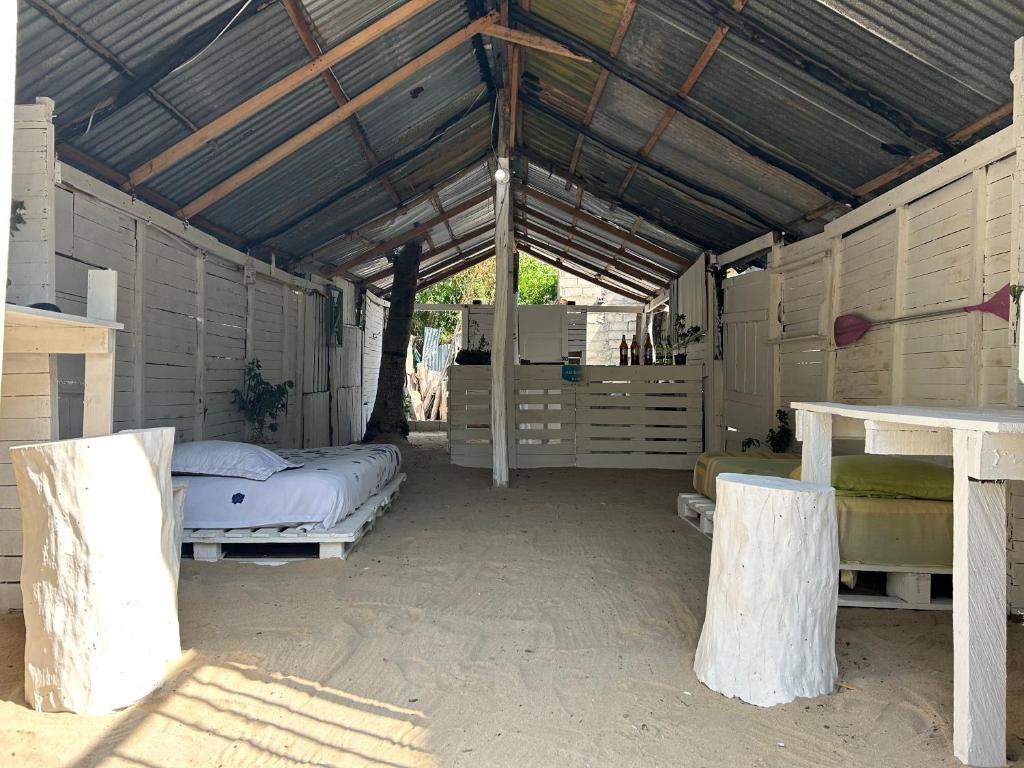 a room with two beds and a table in it at “SandSerenity EcoHostal Punta Arena” in Cartagena de Indias
