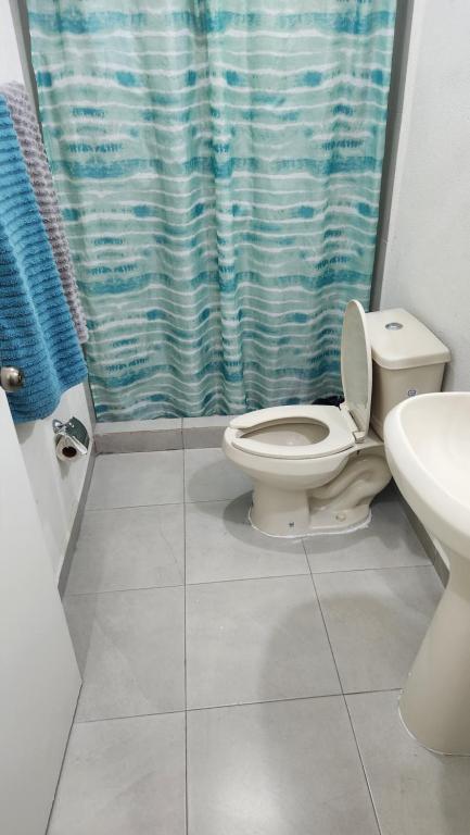 La salle de bains est pourvue de toilettes et d'un rideau de douche. dans l'établissement Salamanca Residencial, à Hermosillo