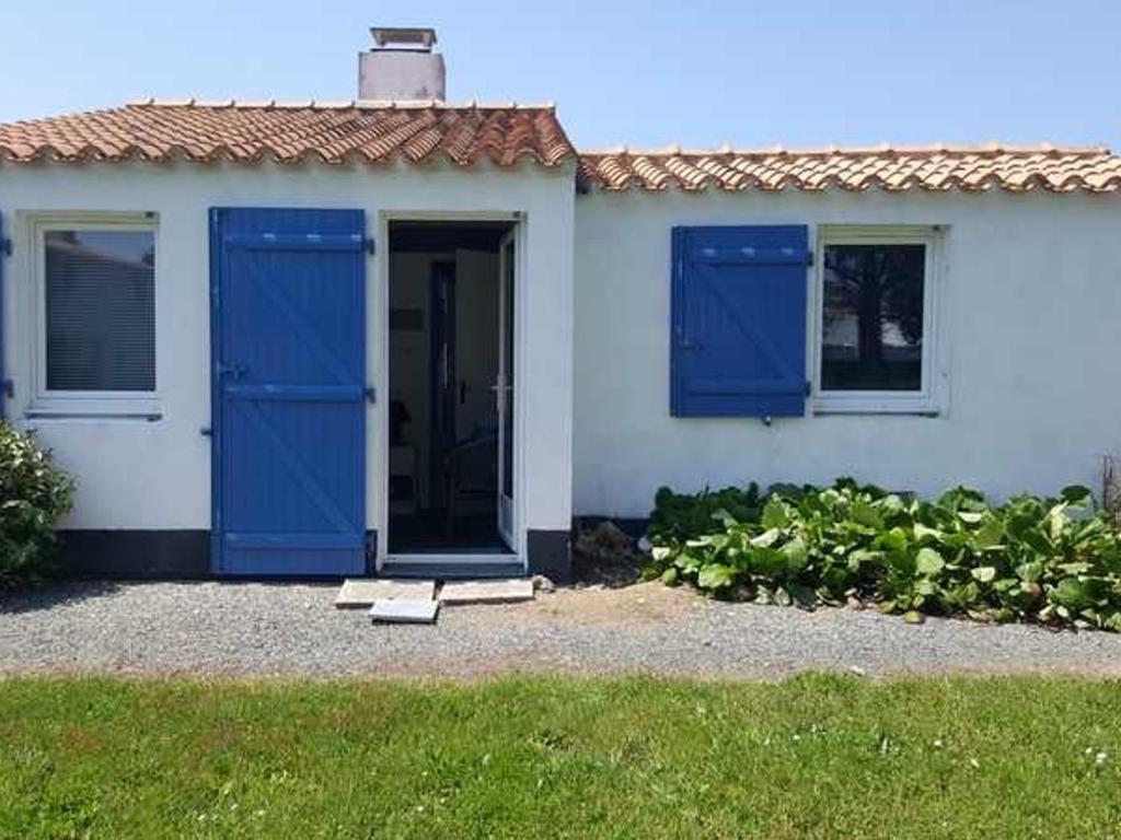 Weißes Haus mit blauer Tür und Fenstern in der Unterkunft Maison Bretignolles-sur-Mer, 3 pièces, 4 personnes - FR-1-231-300 in Brétignolles-sur-Mer
