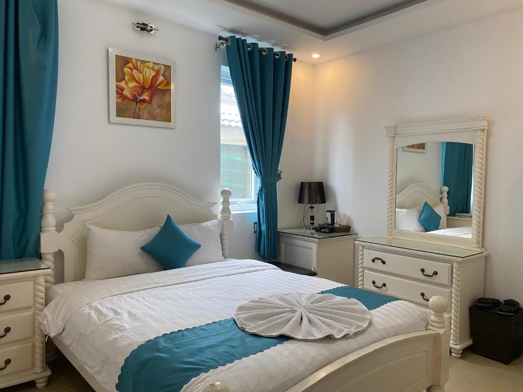 Schlafzimmer mit einem weißen Bett und einem Spiegel in der Unterkunft THIÊN SANG HOTEL in Xuan An