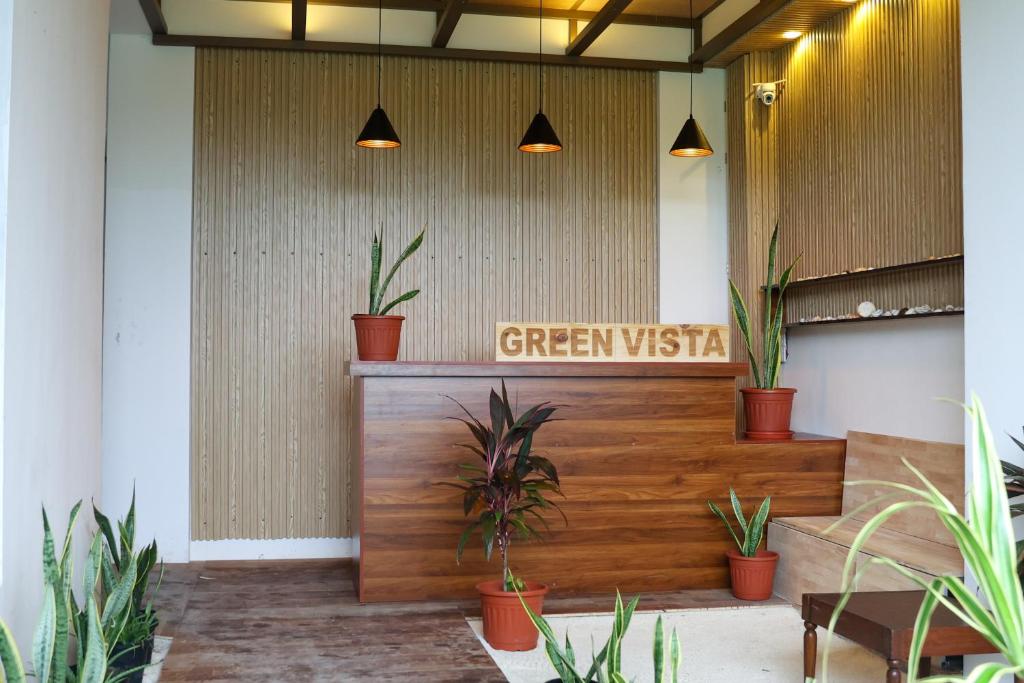 een lobby met een groen visumbord en planten bij Green Vista Maafushi in Maafushi