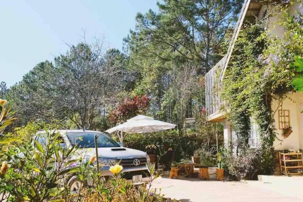 a car parked next to a house with an umbrella at Family house - stay on pine hill Dalat in Xuan An