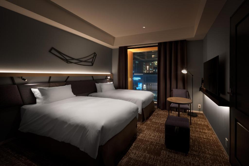 a hotel room with two beds and a window at Nest Hotel Osaka Umeda in Osaka