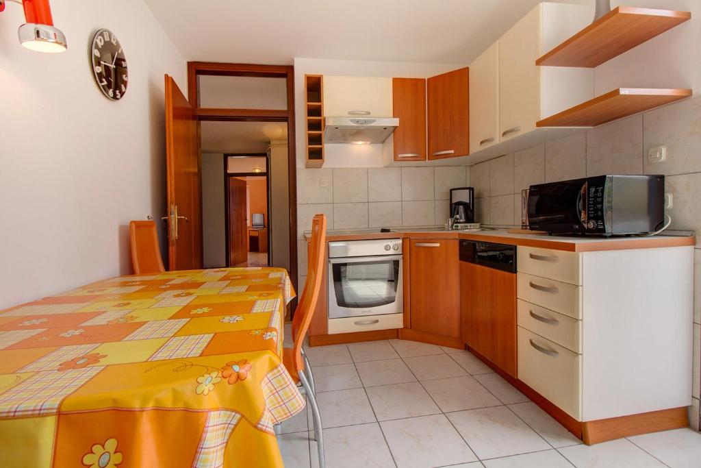 a small kitchen with a table and a microwave at Apartment Mario in Mali Lošinj