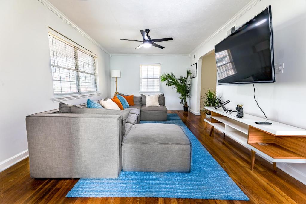 ein Wohnzimmer mit einem grauen Sofa und einem Flachbild-TV in der Unterkunft Luxury home 5 mins to Mercedes-Benz Stadium in Atlanta