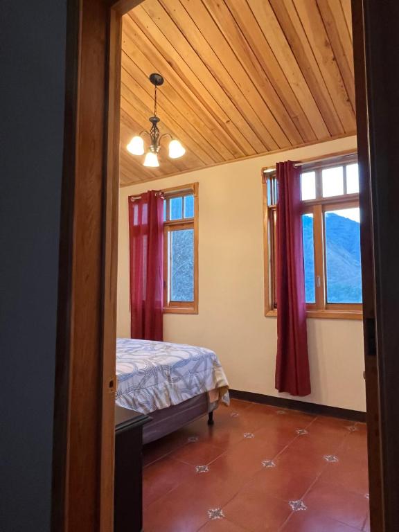 1 dormitorio con 1 cama y 2 ventanas en Casa Atitlan I, en San Juan La Laguna
