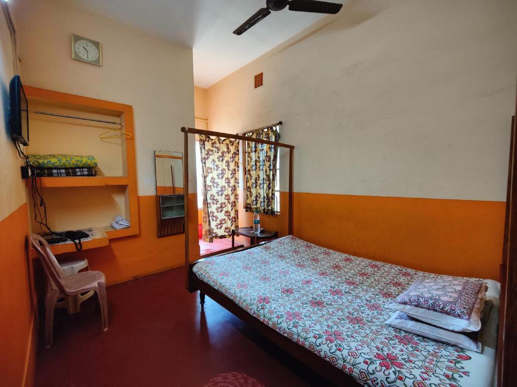 Schlafzimmer mit einem Bett und einem Fenster in der Unterkunft Monalisa Lodge in Vishnupur