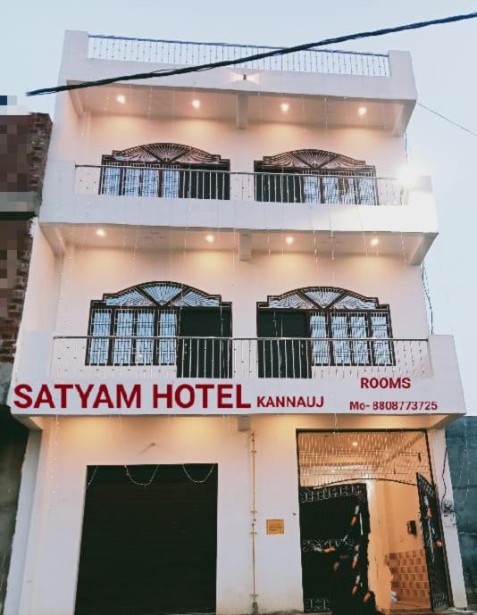 un hotel con un cartello sul lato di un edificio di Satyam Hotel a Kannauj