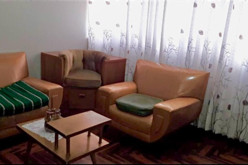 een woonkamer met 2 stoelen en een bank bij Departamento vintage in Huancayo