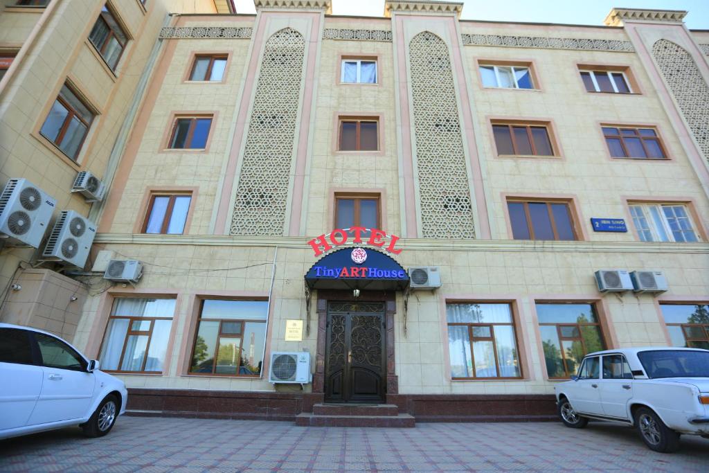 budynek z dwoma samochodami zaparkowanymi przed nim w obiekcie TINY ART HOUSE HOTEL near Airport of Samarkand w Samarkandzie