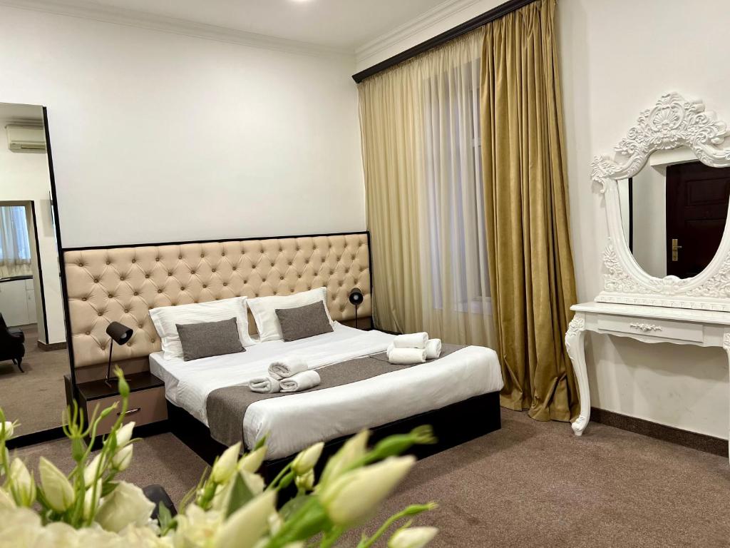 Pokój hotelowy z łóżkiem i lustrem w obiekcie YVN Tumanyan apart-hotel w Erywaniu