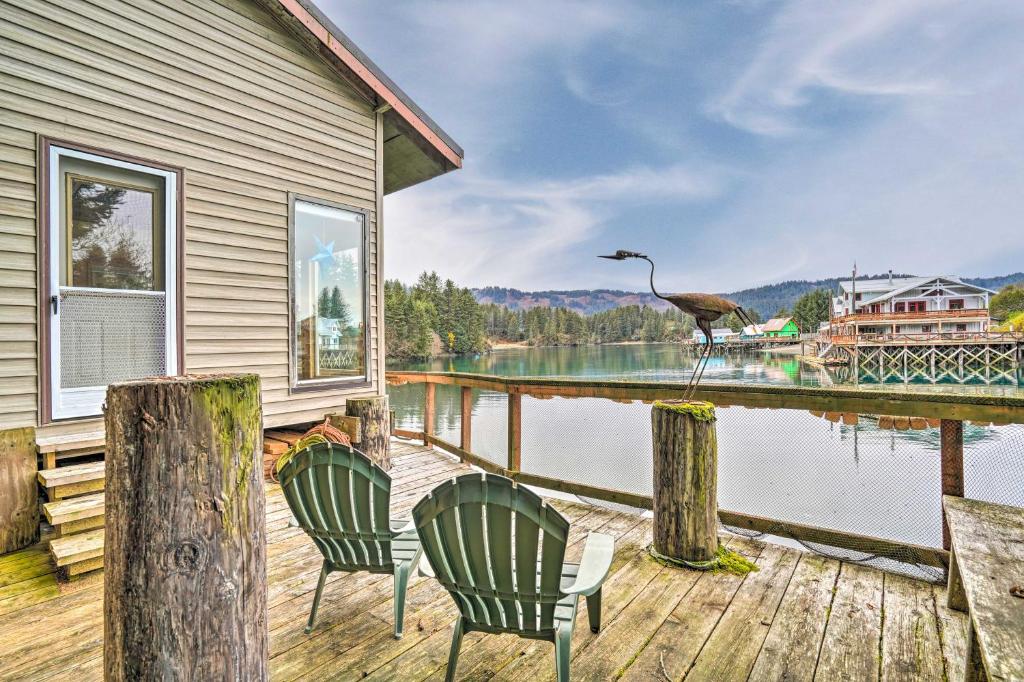 Una casa con dos sillas y un pájaro en un muelle. en Serene Seldovia Cabin, en Seldovia