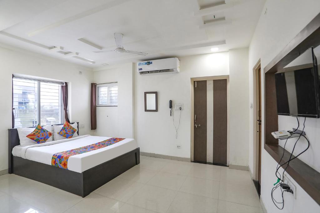 a bedroom with a bed and a flat screen tv at FabHotel HRG Destiny in Nagpur