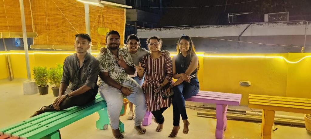 a group of people sitting on a bench at KyGo Hostels in Hyderabad