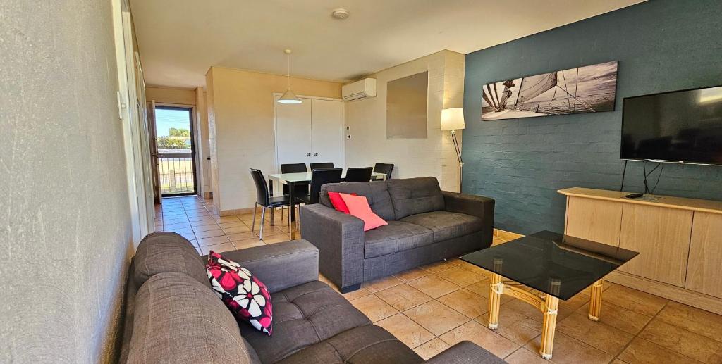 ein Wohnzimmer mit Couch und ein Esszimmer in der Unterkunft Riverview Holiday Apartment 54 - Kalbarri WA in Kalbarri