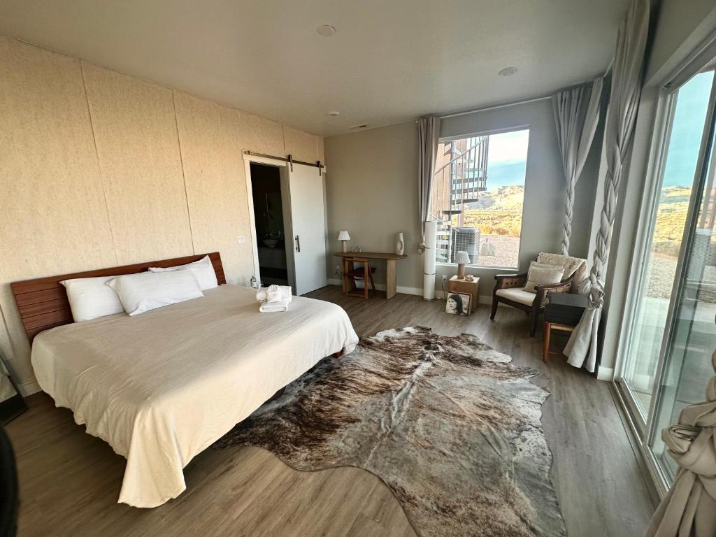 a bedroom with a large bed and a large window at Canyon Oasis suite with Grand Mesa view in Big Water