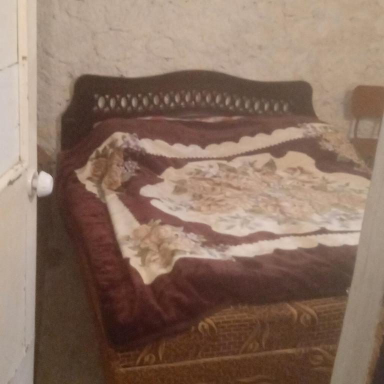 - un lit avec une couverture brune et blanche dans l'établissement Мргануш, à Meghri