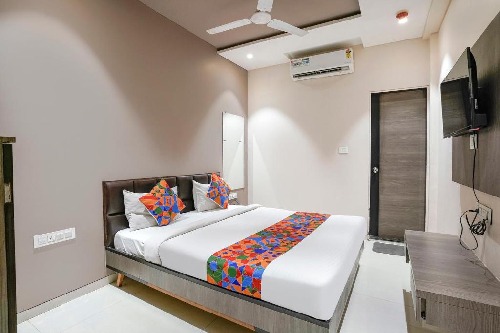 ein Schlafzimmer mit einem großen Bett und einem TV in der Unterkunft FabExpress Ospite in Surat