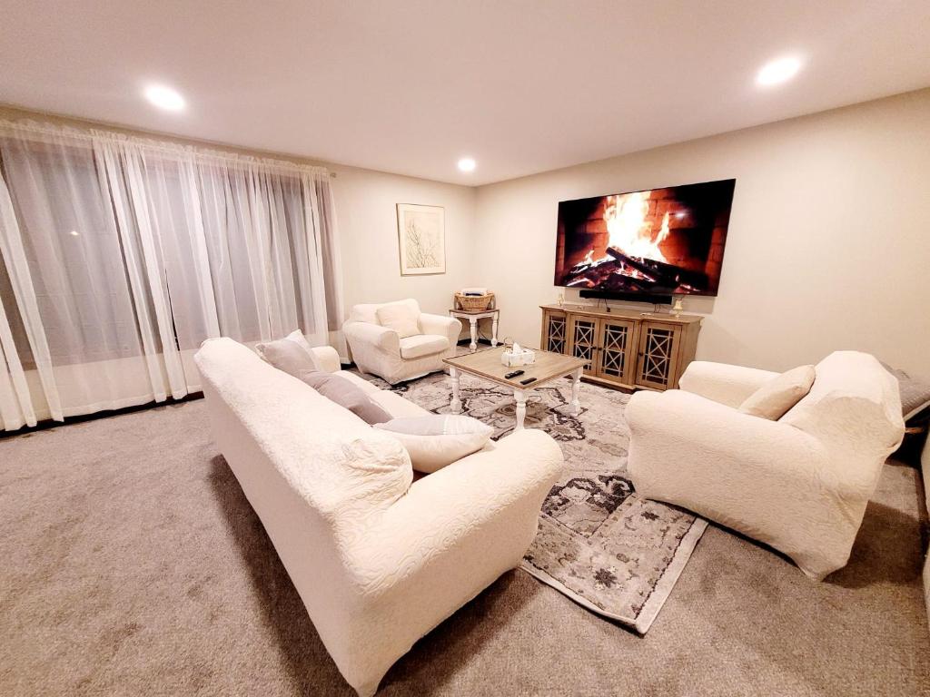 uma sala de estar com mobiliário branco e uma televisão de ecrã plano em Spacious Buffalo Niagara Falls Apt, Close to Buffalo Airport em Depew