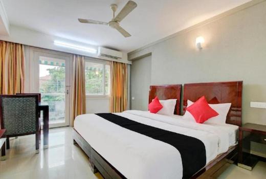 ein Schlafzimmer mit einem großen weißen Bett mit roten Kissen in der Unterkunft AEC Travel and Leisure Solution Pvt Ltd in Alappuzha