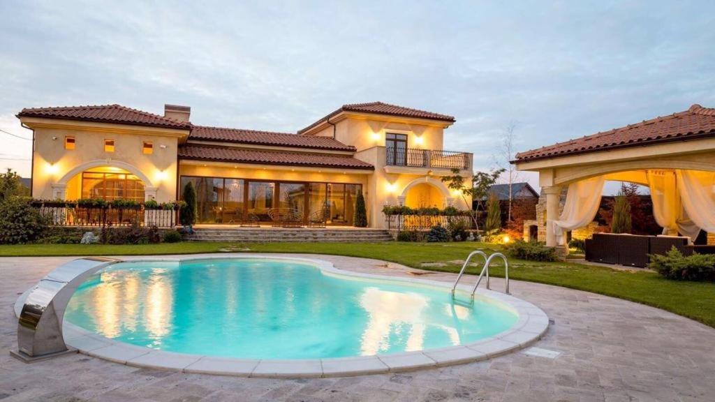 une grande piscine en face d'une maison dans l'établissement Vila in stil mediterranean, à Crevedia