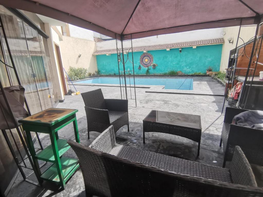 eine Terrasse mit einem Tisch, Stühlen und einem Pool in der Unterkunft ARTE Y CIENCIA in Lima