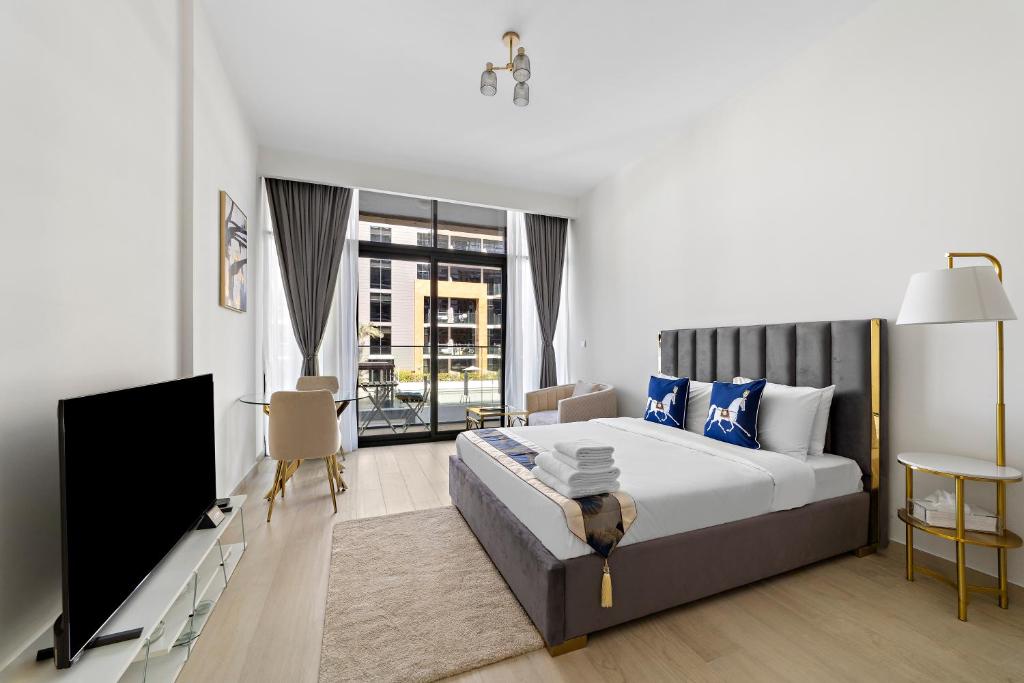 um quarto com uma cama e uma televisão de ecrã plano em Modern Studio Apt in Meydan em Dubai
