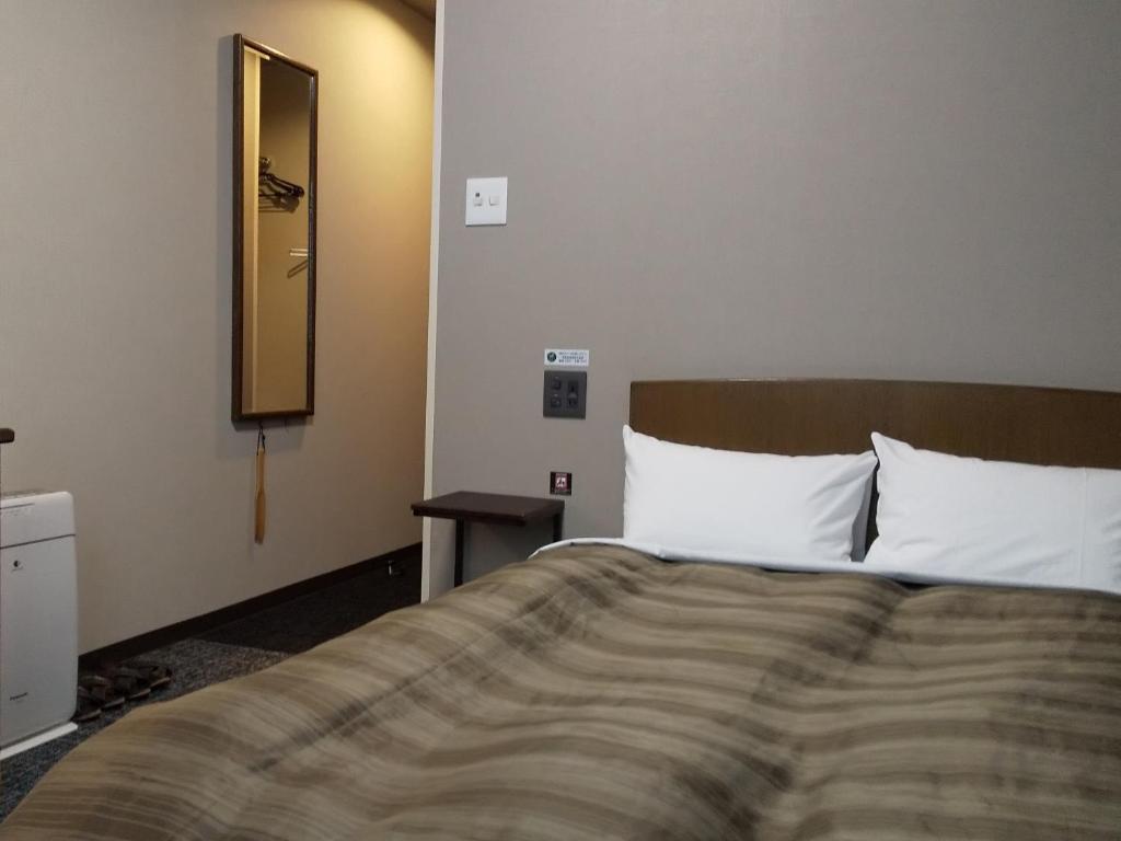 Postel nebo postele na pokoji v ubytování Hotel Route-Inn Tsu Ekiminami -Kokudo23gou-