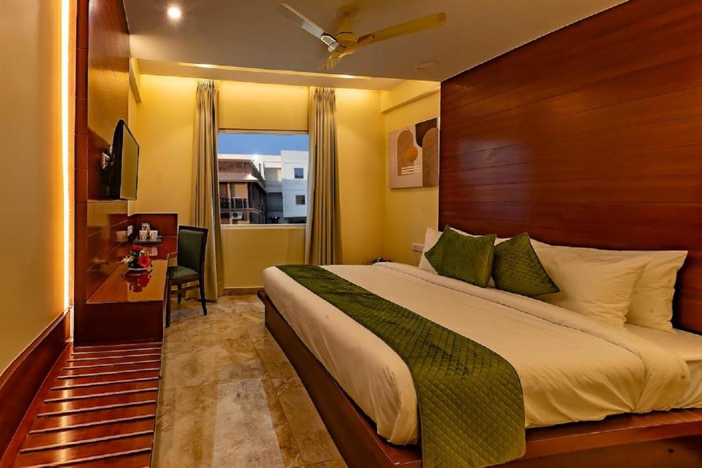 a bedroom with a large bed with a wooden headboard at Five Elements Hotels Mertiya Residency in Jodhpur