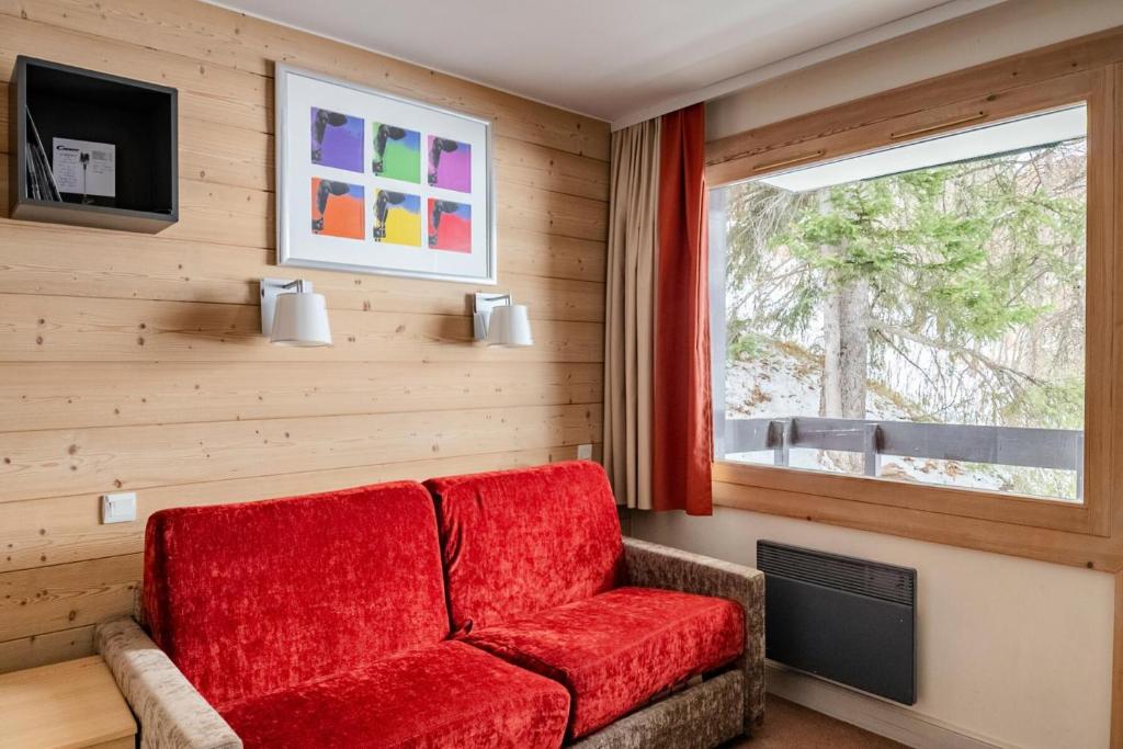 - un canapé rouge dans une chambre avec fenêtre dans l'établissement Résidence Plagne Lauze - maeva Home - Studio 2 Personnes - Confort MAE-0154, à Mâcot La Plagne