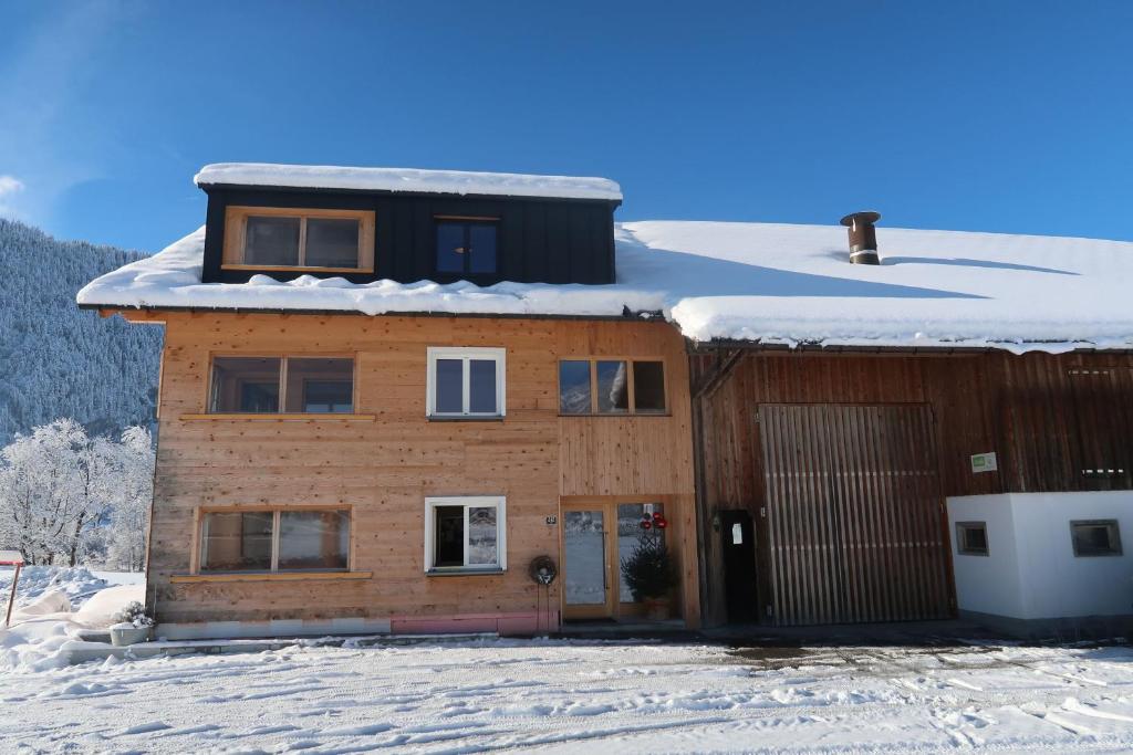 een huis met sneeuw erop bij Ferienwohnung Mian in Bezau