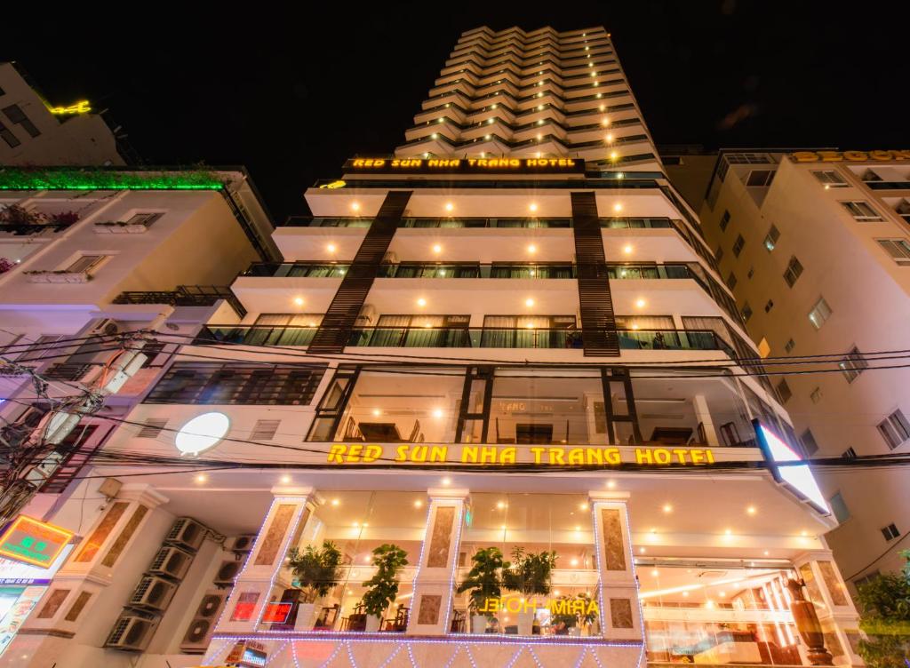 um edifício branco alto com um cartaz em Red Sun Nha Trang Hotel em Nha Trang