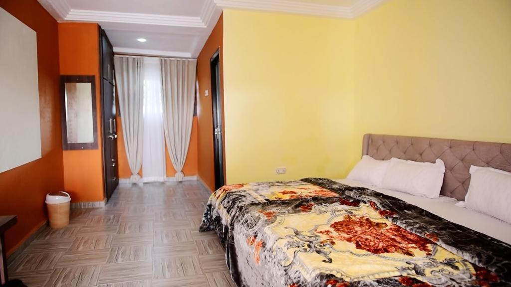 1 dormitorio con 1 cama grande en una habitación en C-VISION GUESTHOUSE, en Sefwi Bekwai