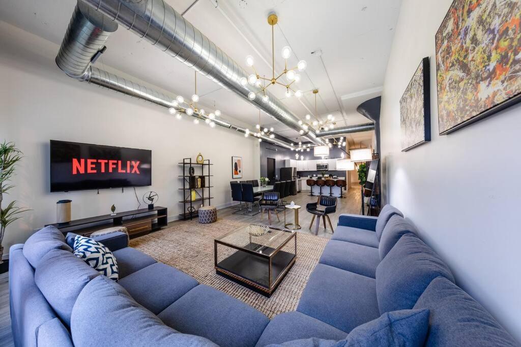 ein Wohnzimmer mit einem blauen Sofa und einem TV in der Unterkunft McCormick 6B/3Ba Luxury Suite for groups/12 guests with optional Parking in Chicago