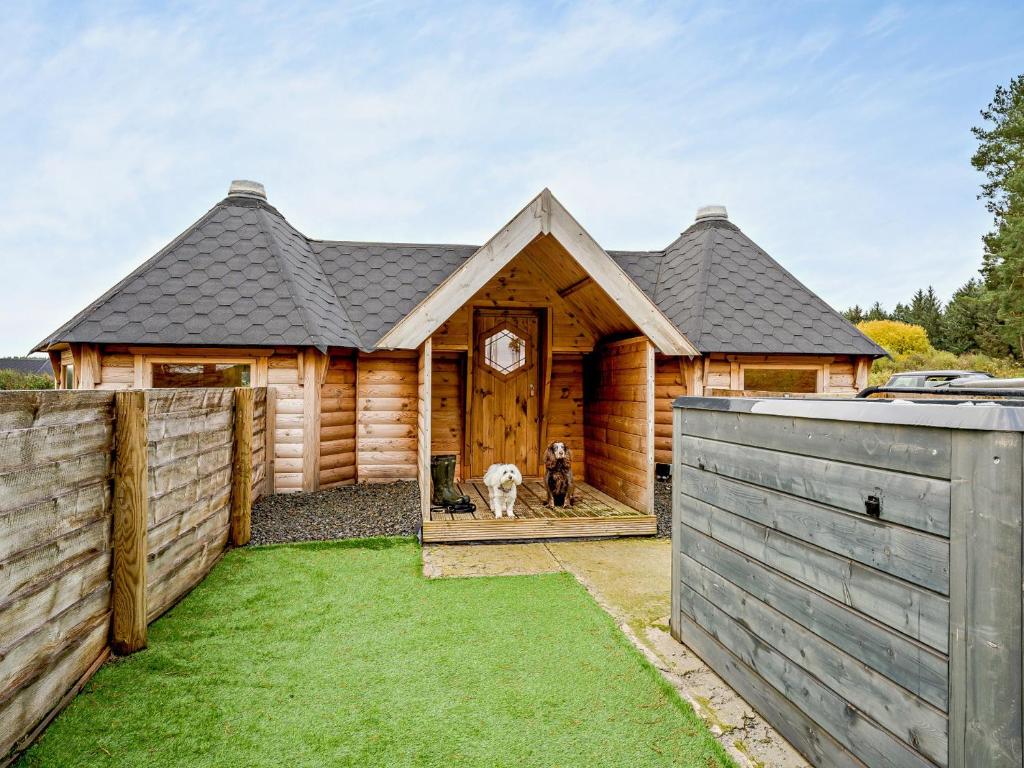 a wooden house with a dog standing in the doorway at 1 Bed in Libberton 91247 in Libberton