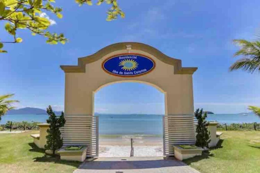 un edificio con un arco frente a la playa en No mar, condomínio pé na areia, en Florianópolis