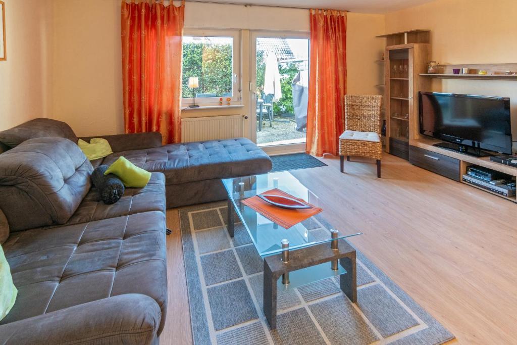 a living room with a couch and a tv at Huus de Ruh in Dornumergrode