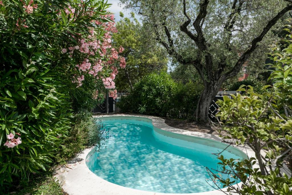 - une piscine dans un jardin planté d'arbres et de fleurs dans l'établissement MATTEOTTi Apartments, à Desenzano del Garda