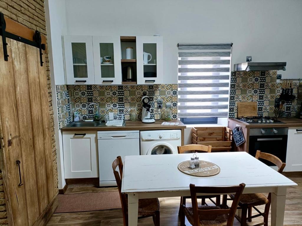 una cucina con tavolo bianco, tavolo e sedie di L'Oustal a Montech