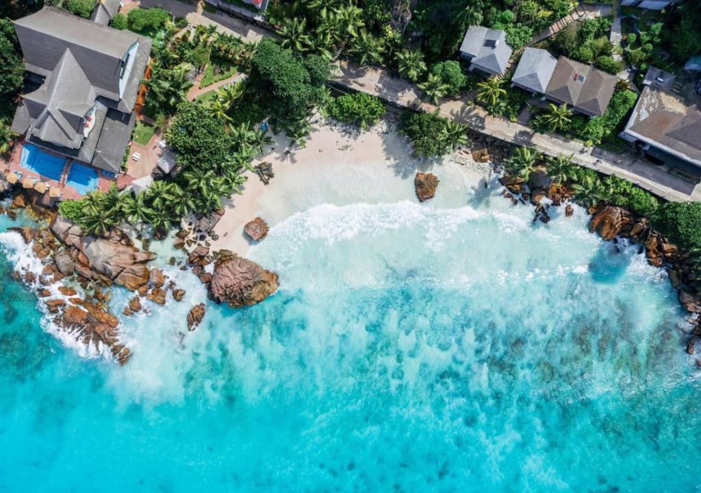 拉迪格島的住宿－帕特坦村酒店，享有海滩的空中景色,包括岩石和水