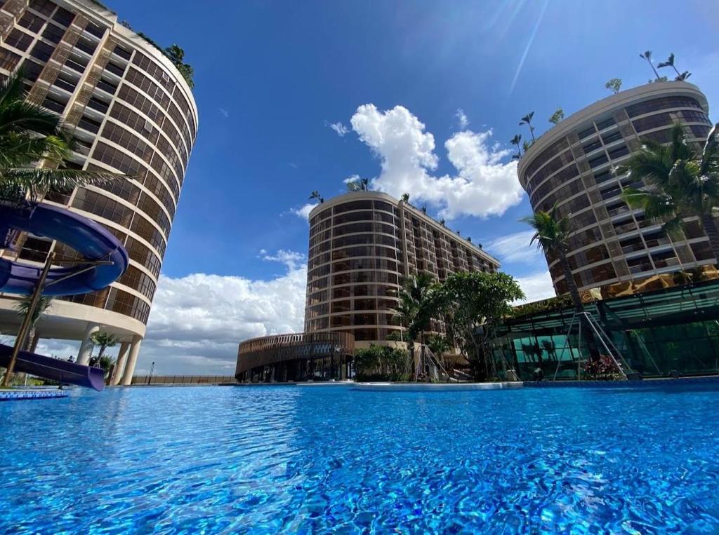 a large swimming pool in front of two buildings at Cozy Private Studio with Luxurious Pool & Gym by SYM B622 in Phnom Penh