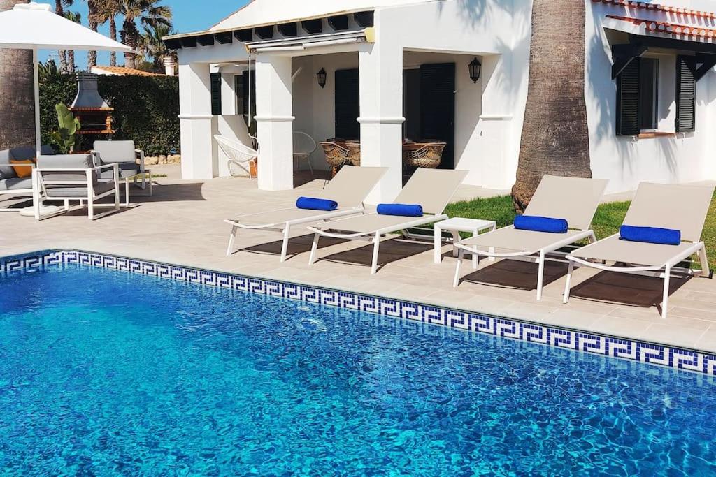 un gruppo di sedie e una piscina di Villa Juanes. Encanto, privacidad y relax. a Cala'n Bosch