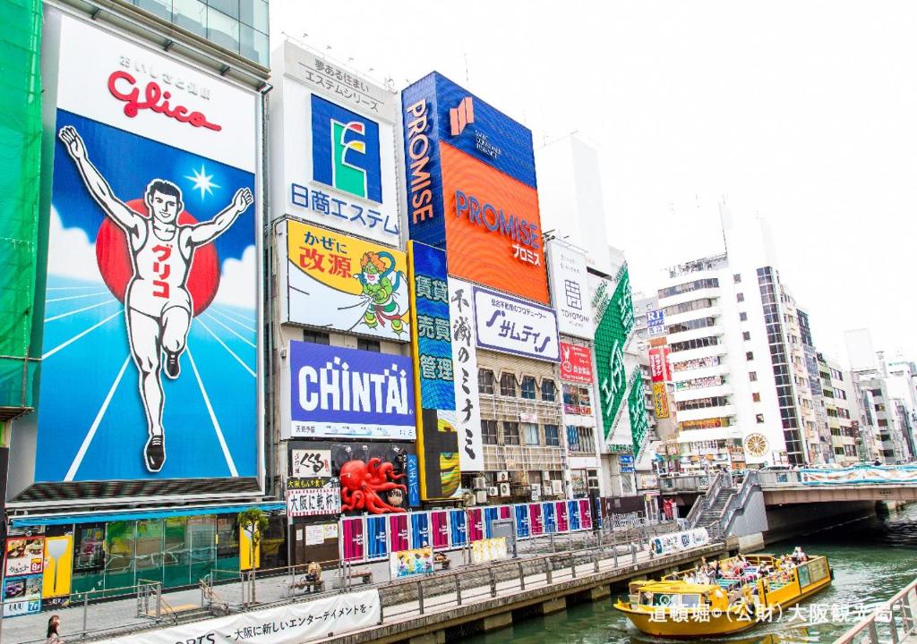 a city with a river and buildings and a city with signs at APA Hotel Tennoji Ekimae in Osaka