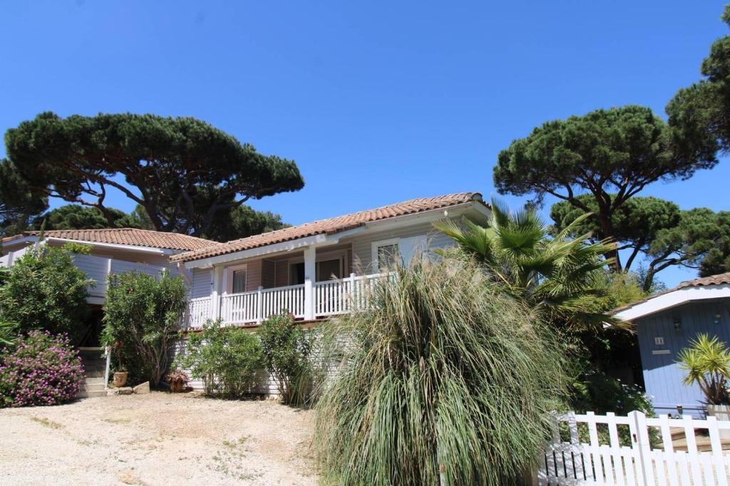 une maison avec une clôture blanche et des arbres dans l'établissement GASMIM41 - Golfe de St-Tropez - Chalet 3 chambres climatisé dans domaine privé, à Gassin