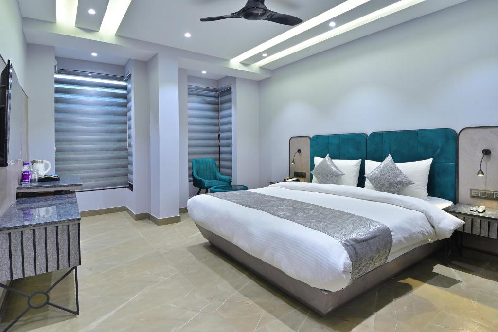 a bedroom with a large bed and a large window at Hotel Uptown Delhi - By La Exito Hotels in New Delhi