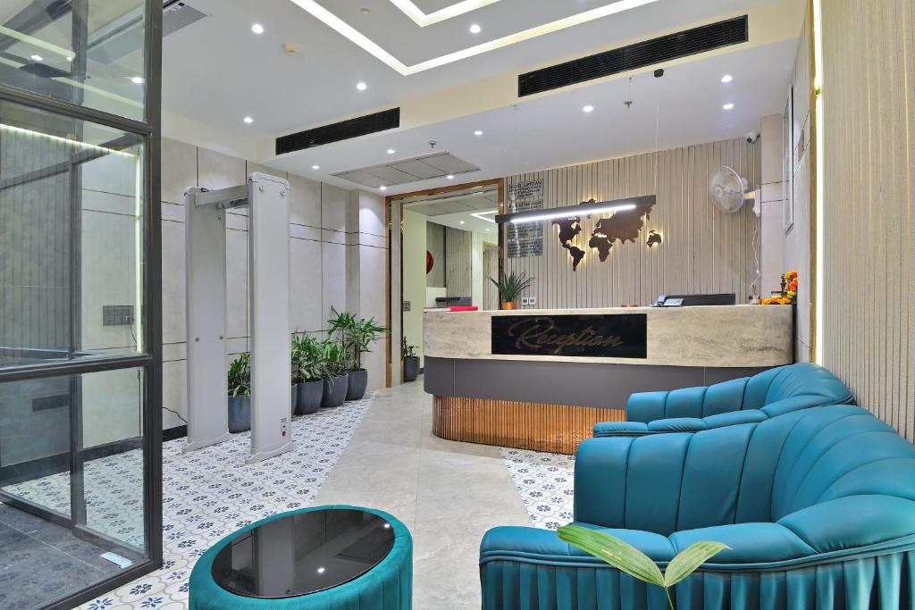 an office lobby with blue chairs and a reception desk at Hotel Uptown Delhi - By La Exito Hotels in New Delhi